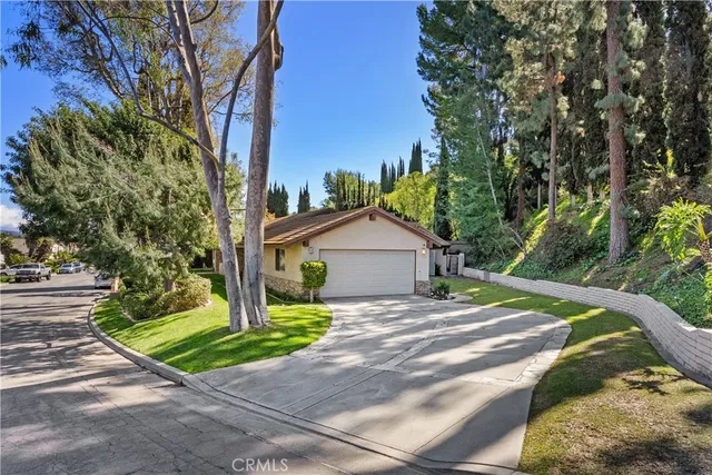 a view of a house with a yard and large tree