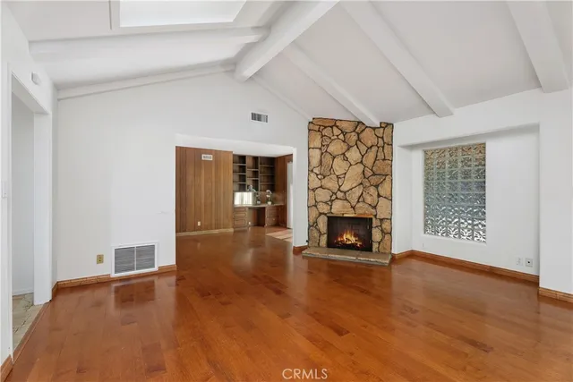 a view of an empty room with a fireplace and window