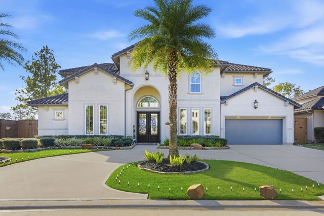 a front view of a house with a garden and trees