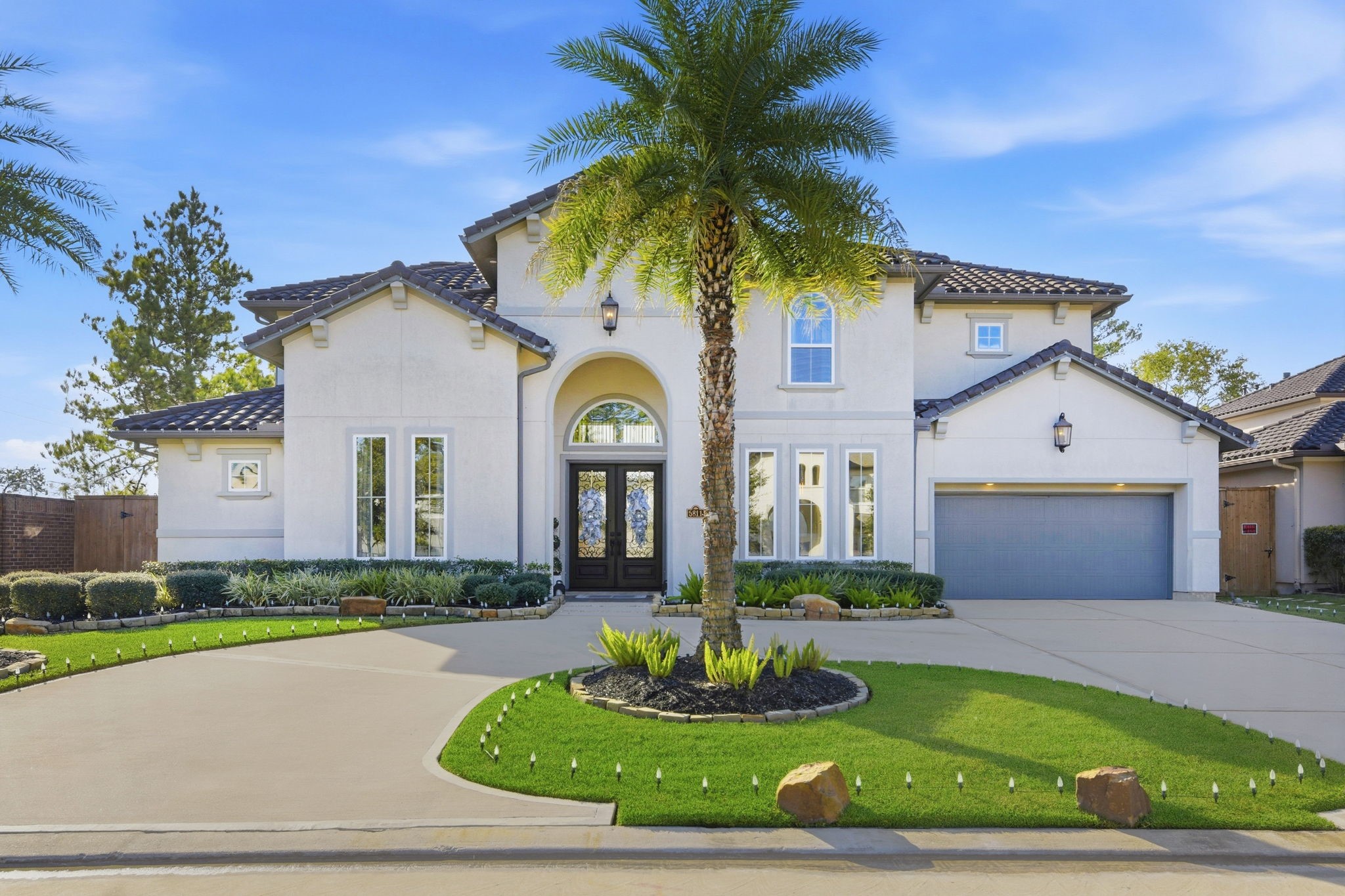 a front view of a house with a garden and trees