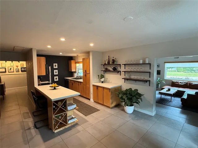 a room with stainless steel appliances kitchen island granite countertop lots of counter top space