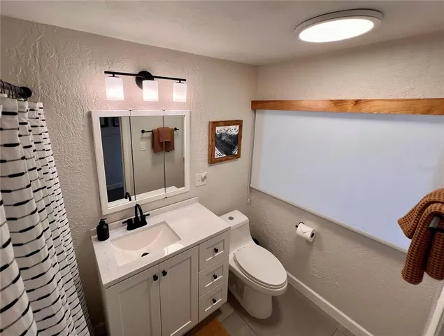 a bathroom with a sink a toilet and mirror