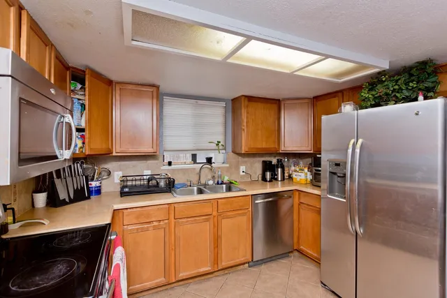 a kitchen with sink a refrigerator and cabinets