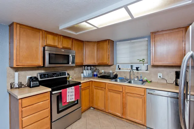 a kitchen with a sink stove top oven and refrigerator