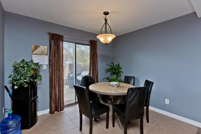 a dining room with furniture potted plants and wooden floor
