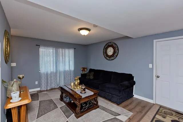 a living room with furniture a rug and a window