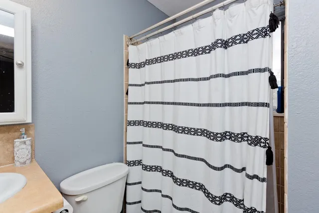 a bathroom with a toilet and a shower