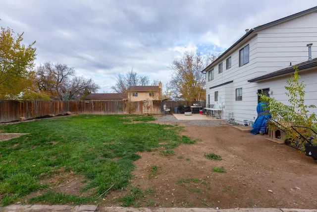 a patio with table and chairs and potted plants