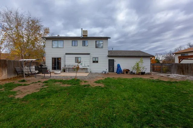a view of a white house in a big yard