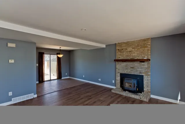 a view of an empty room with window and fire place