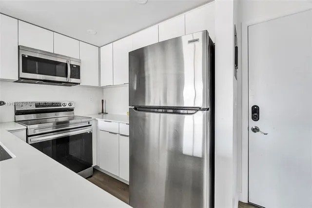 a kitchen with stainless steel appliances and refrigerator