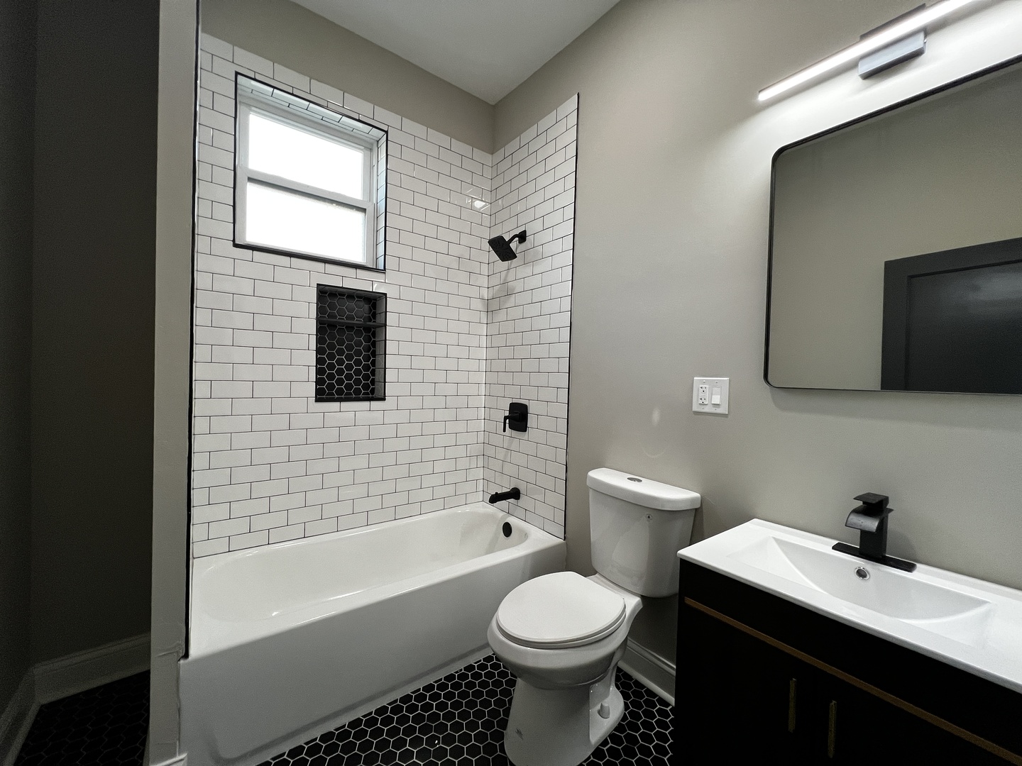 4956 West Erie Street, Unit 1 Chicago, IL 60644 - Photo 12 of 25 a bathroom with a toilet a sink a mirror and bathtub
