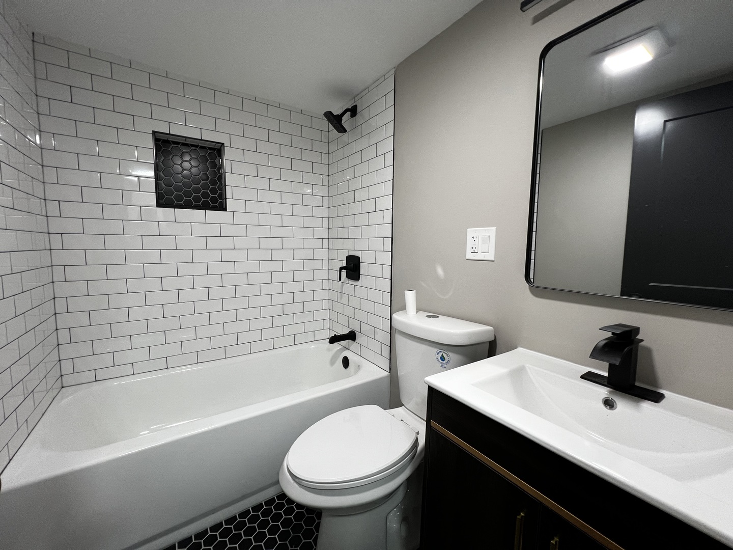 4956 West Erie Street, Unit 1 Chicago, IL 60644 - Photo 17 of 25 a bathroom with a sink toilet a mirror and bathtub