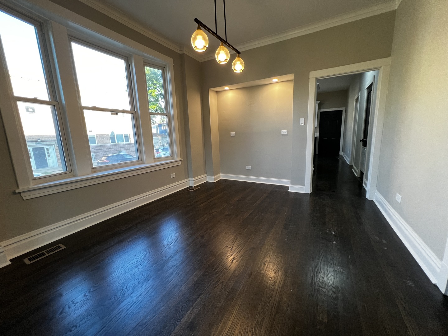 4956 West Erie Street, Unit 1 Chicago, IL 60644 - Photo 5 of 25 an empty room with wooden floor and windows