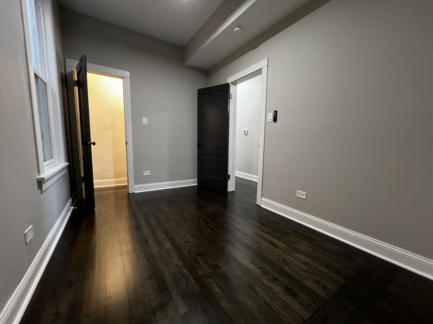 4956 West Erie Street, Unit 1 Chicago, IL 60644 - Photo 9 of 25 an empty room with wooden floor and windows