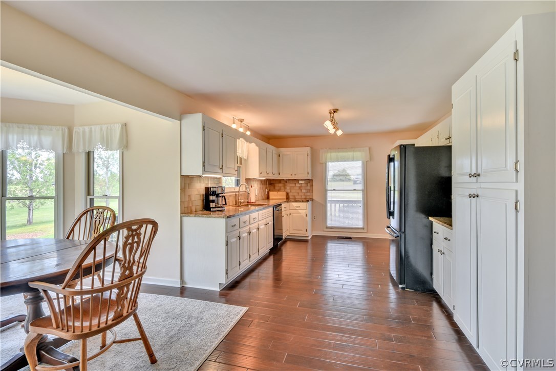 2661 Bibb Store Road Louisa, VA 23093 - Photo 11 of 35 a kitchen with stainless steel appliances granite countertop a refrigerator a stove top oven a sink dishwasher and white cabinets with wooden floor