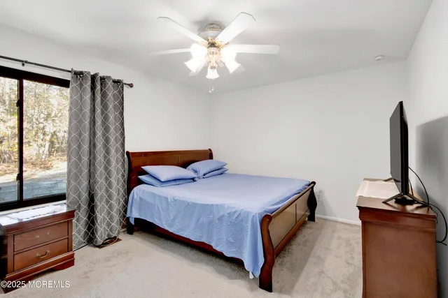 a bedroom with a bed and a flat tv screen on dresser