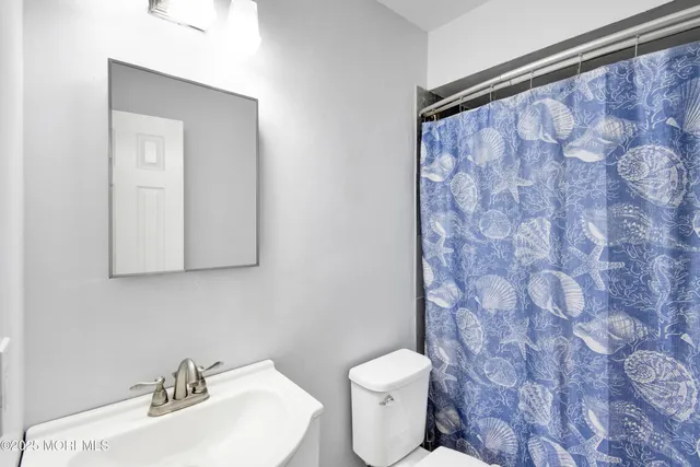 a bathroom with a toilet a sink and a mirror