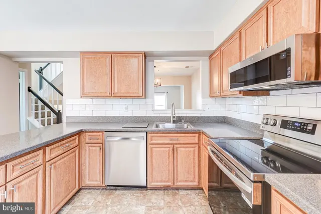 a kitchen with stainless steel appliances granite countertop a sink stove and microwave