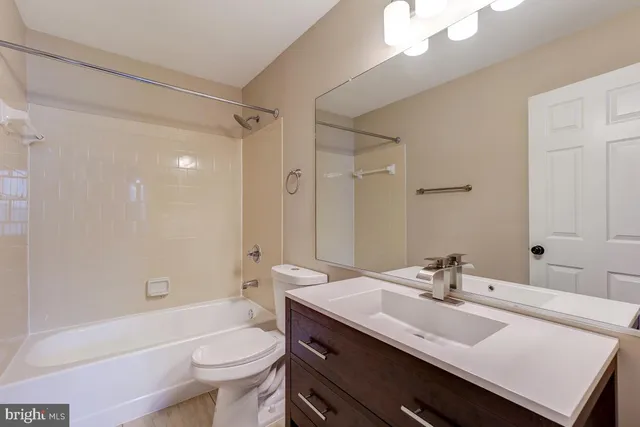 a bathroom with a sink a toilet a tub and a mirror
