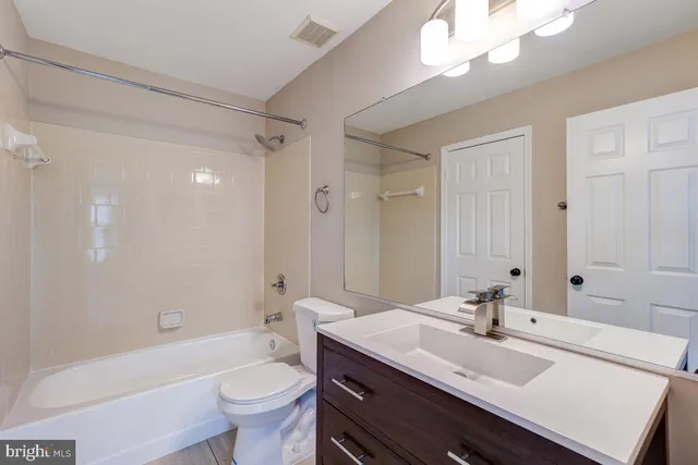 a bathroom with a sink a toilet a large mirror and shower