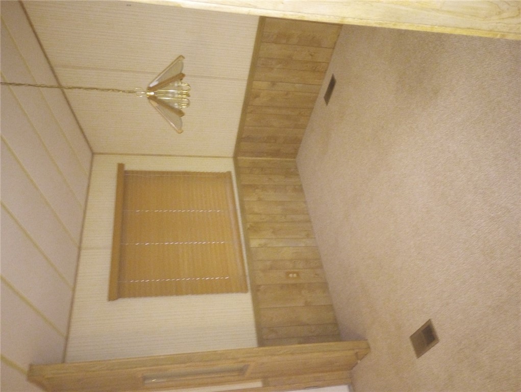 1682 Toro Road Bullhead City, AZ 86442 - Photo 12 of 30 Empty room with carpet, wallpapered walls, wood walls, and a wainscoted wall