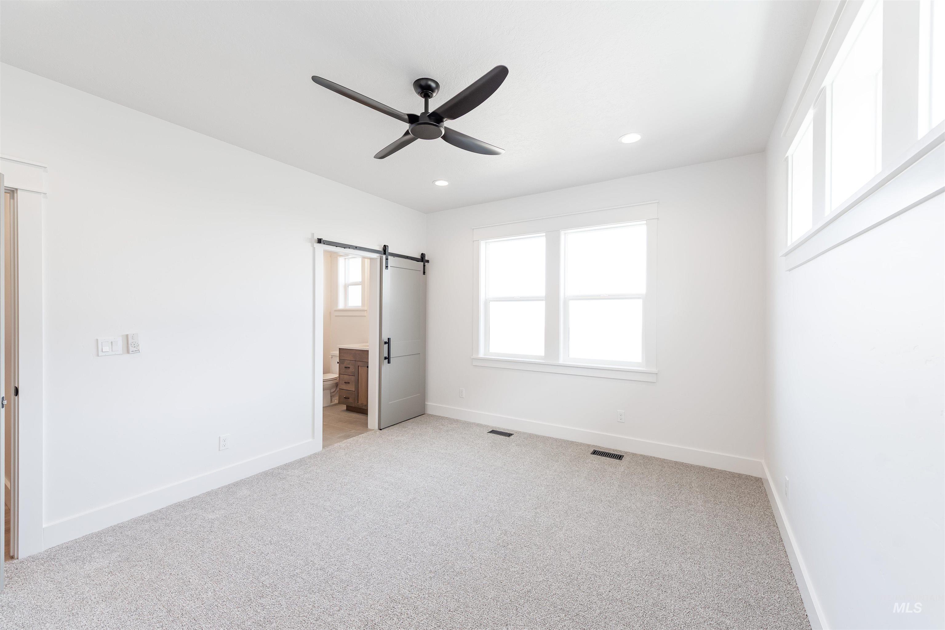 410 South Diesel Way Boise, ID 83716 - Photo 15 of 49 Unfurnished bedroom featuring light carpet, ceiling fan, connected bathroom, recessed lighting, and a barn door