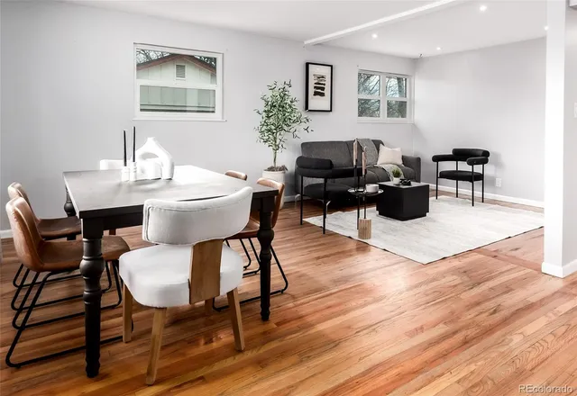 a living room with furniture a table and wooden floor