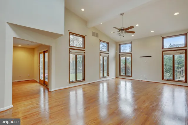 a view of an empty room with a window and wooden floor