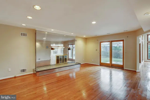 a view of staircase with lots of frames on wall and wooden floor