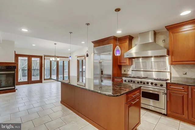 a kitchen with stainless steel appliances granite countertop a sink dishwasher and a wooden cabinets with a large window