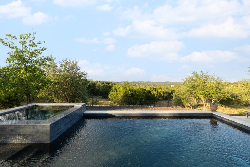 32045 Mirela Ann Road Dripping Springs, TX 78620 - Photo 29 of 30 An inviting swimming pool and spa look out over rolling hills and mature trees.