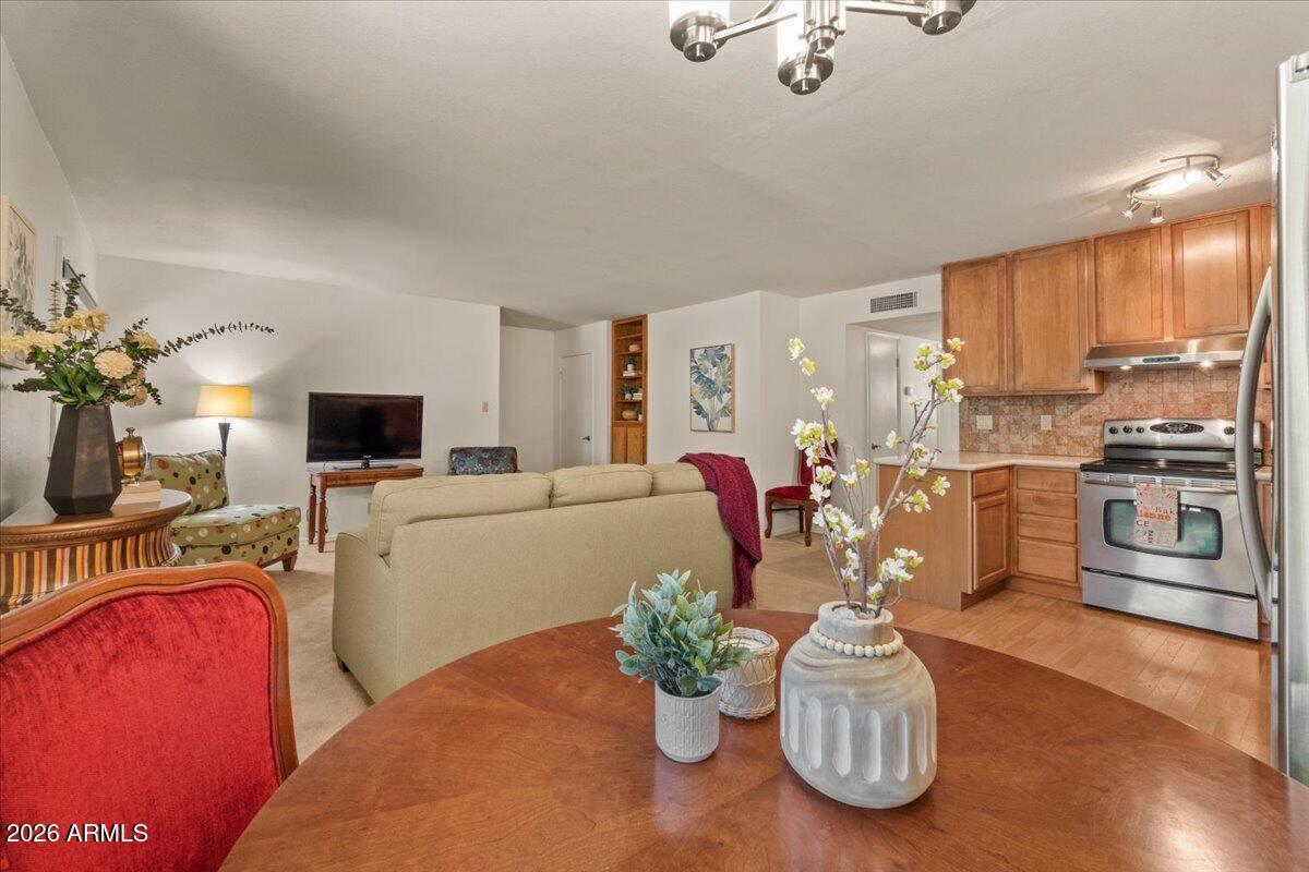 5525 East Thomas Road, Unit O12 Phoenix, AZ 85018 - Photo 7 of 27 a living room with furniture a flat screen tv and a dining table