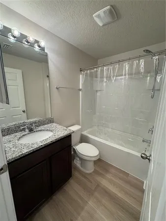a bathroom with a granite countertop sink toilet and shower