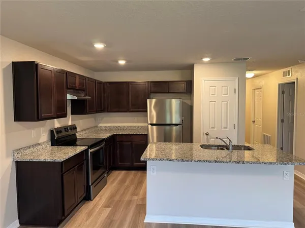 a kitchen with stainless steel appliances granite countertop a sink stove and refrigerator