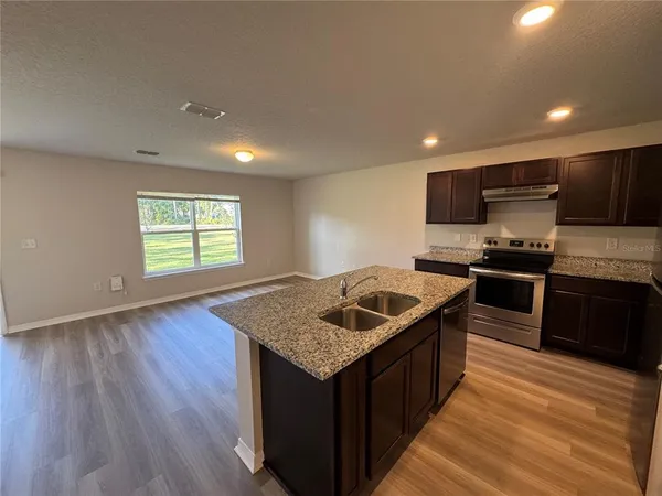 a kitchen with a stove sink and cabinets