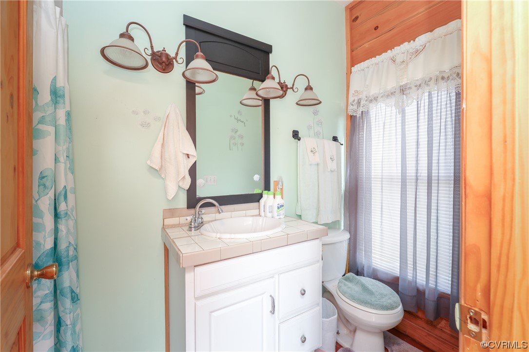 3913 Woodland Church Road Buckingham, VA 23921 - Photo 28 of 50 a bathroom with a granite countertop sink toilet and a mirror