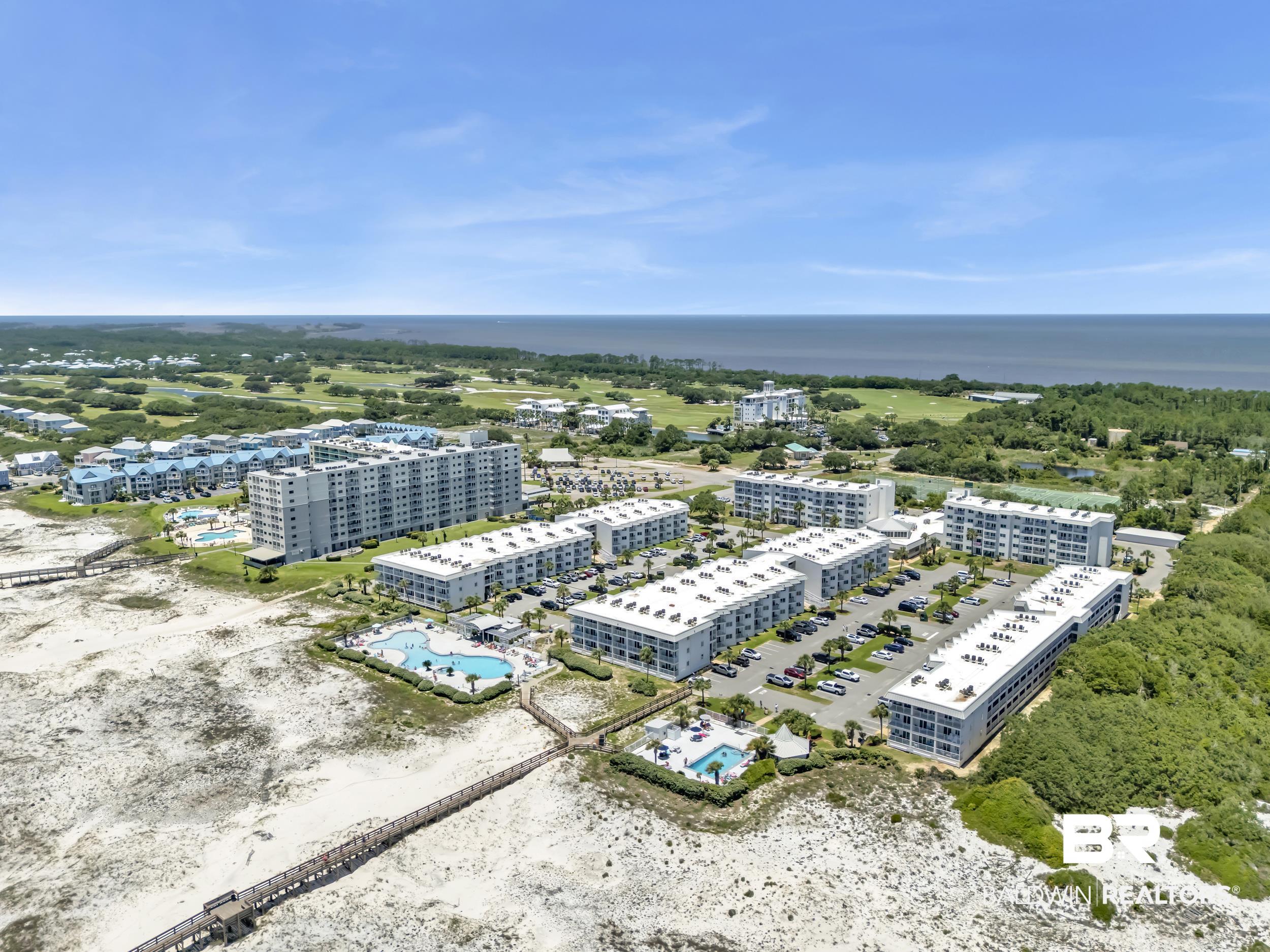 400 Plantation Road, Unit 2118 Gulf Shores, AL 36542 - Photo 53 of 59 Expansive coastal property featuring multiple residential buildings, two outdoor pools, tennis courts, direct beach access via boardwalks, and surrounding natural landscapes