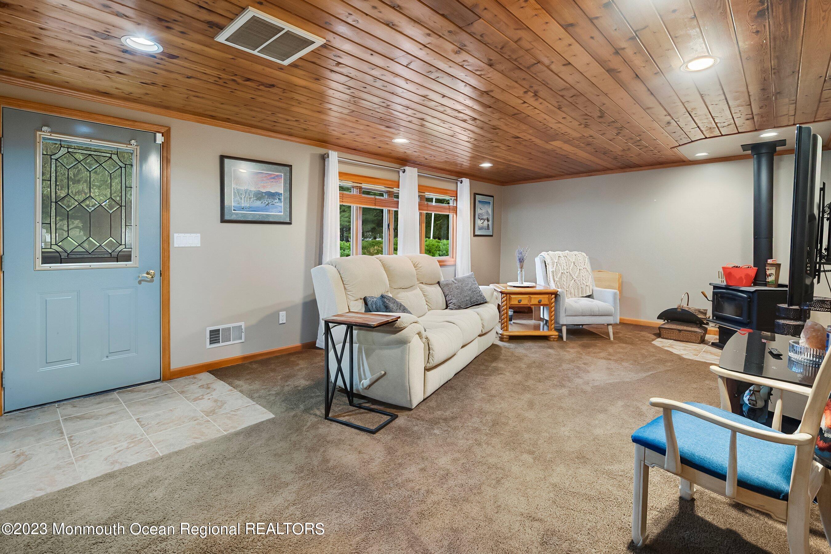 375 Cook Road Jackson, NJ 08527 - Photo 12 of 22 a living room with furniture a flat screen tv and a table