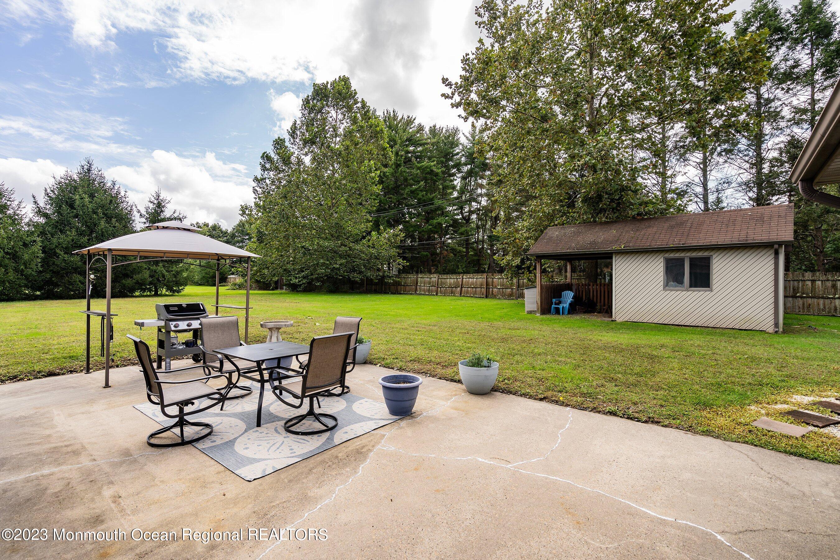 375 Cook Road Jackson, NJ 08527 - Photo 8 of 22 a view of a patio with table and chairs under an umbrella