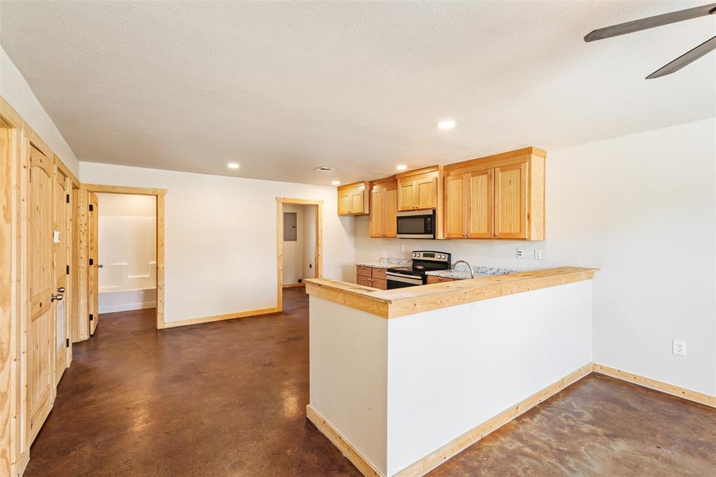 13001 Owen Lane, Unit 13005 Thackerville, OK 73459 - Photo 5 of 15 Kitchen featuring finished concrete floors, appliances with stainless steel finishes, a peninsula, recessed lighting, and light countertops