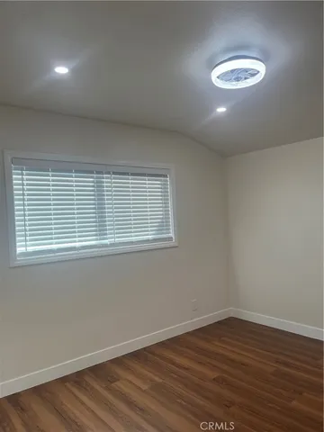 a view of a room with wooden floor and a window