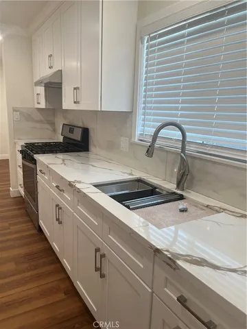 a kitchen with granite countertop white cabinets and white appliances