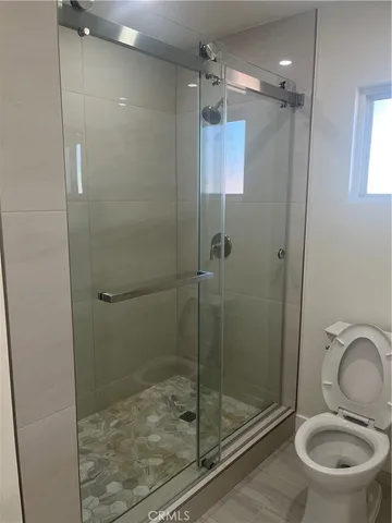 a bathroom with a shower a toilet and sink