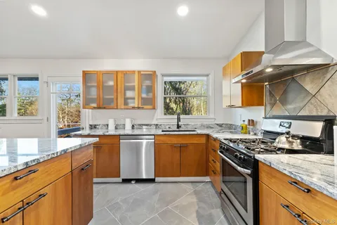 a kitchen with stainless steel appliances granite countertop a stove sink and cabinets