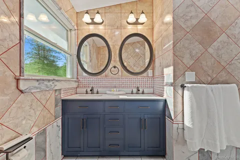 a bathroom with a granite countertop toilet sink and mirror