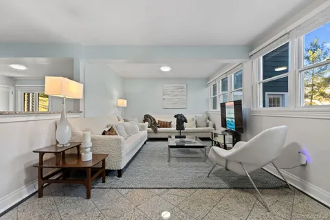 a living room with furniture a flat screen tv and a window