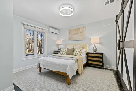 a bedroom with a bed lamp and a window