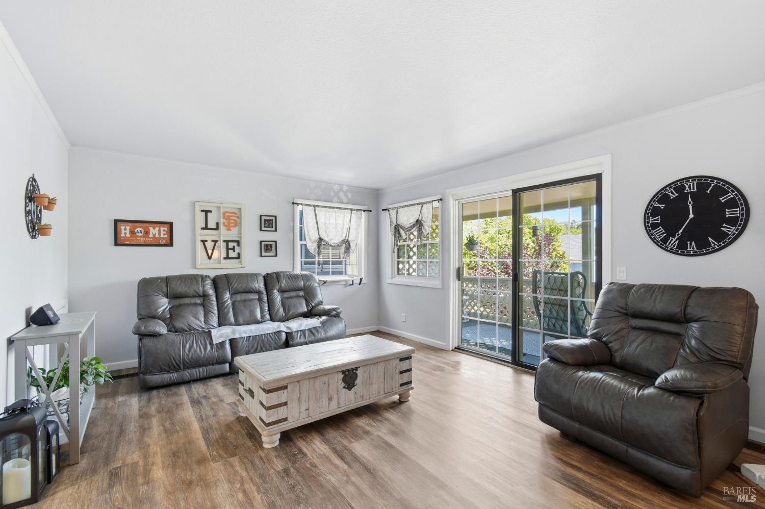 5193 Firestone Place Santa Rosa, CA 95409 - Photo 10 of 35 Bright living room with luxury vinyl plank flooring and a sliding glass door that opens to a private covered deck.