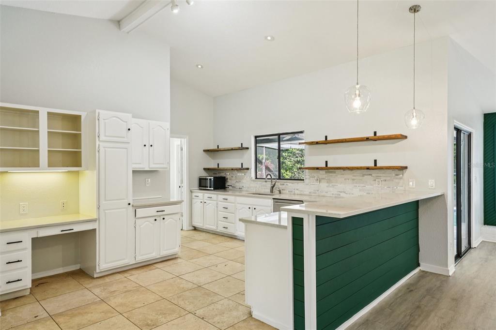 3109 Lake Valencia Lane East Palm Harbor, FL 34684 - Photo 11 of 59 a kitchen with stainless steel appliances kitchen island granite countertop a sink and dishwasher a refrigerator with white cabinets